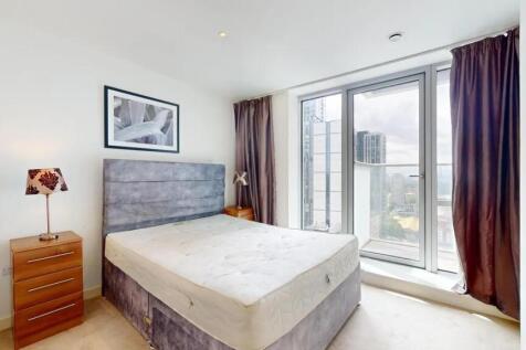 Bright and modern master bedroom featuring a la...