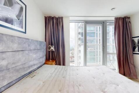 Bright and modern master bedroom featuring a la...