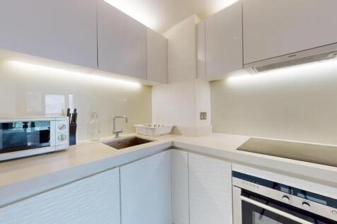 Bright and modern kitchen featuring sleek white...