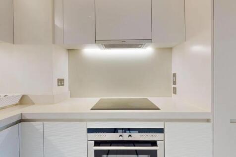 A sleek, modern kitchen featuring clean white c...