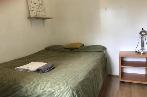 A cozy double bedroom featuring a neatly made b...