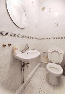 A clean and functional single toilet with white...