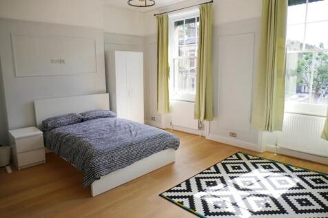 Bright and spacious master bedroom featuring la...