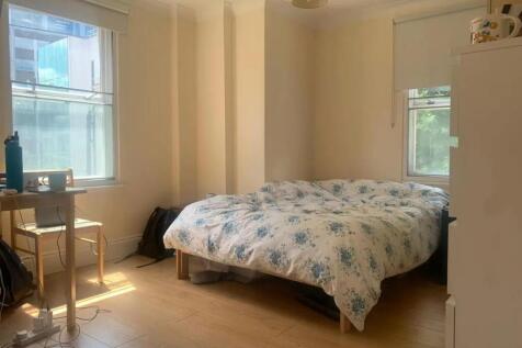 A cozy double bedroom bathed in natural light f...