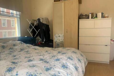 A cozy double bedroom featuring a large window ...