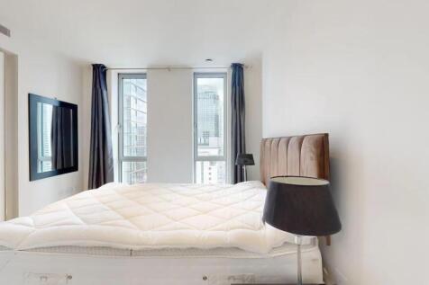 A modern double bedroom featuring a plush uphol...