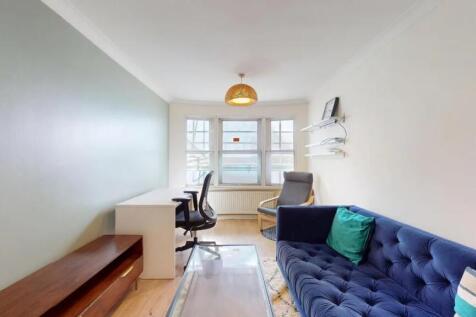 A bright and tidy living room featuring a cozy ...