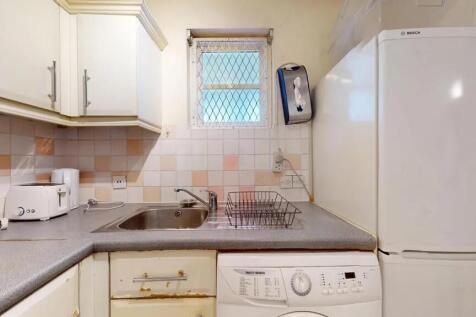 Compact and practical kitchen featuring a stain...