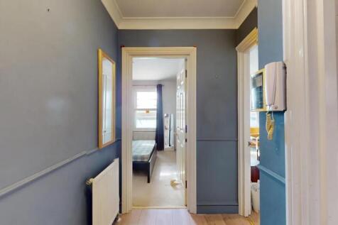 A tidy hallway painted in a modern blue tone wi...