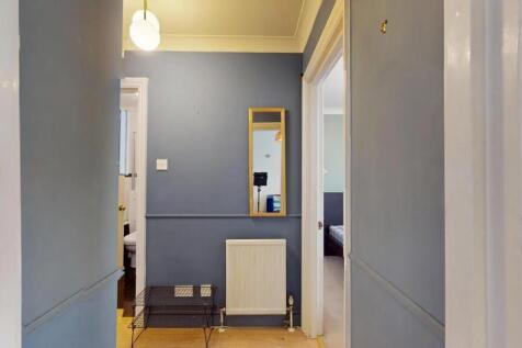 A neat and inviting hallway painted in soft blu...
