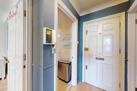 A neat and welcoming hallway featuring a white ...