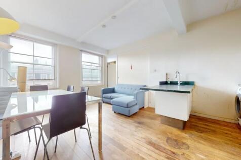 Bright and airy living room featuring large win...