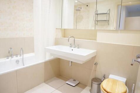 Bright and clean bathroom suite featuring a mod...