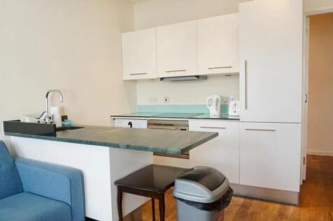 A modern and clean kitchen area featuring white...