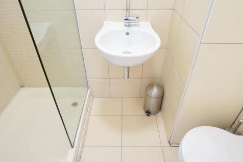 A clean, modern bathroom featuring a walk-in sh...
