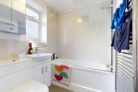 A bright and clean bathroom suite featuring a w...