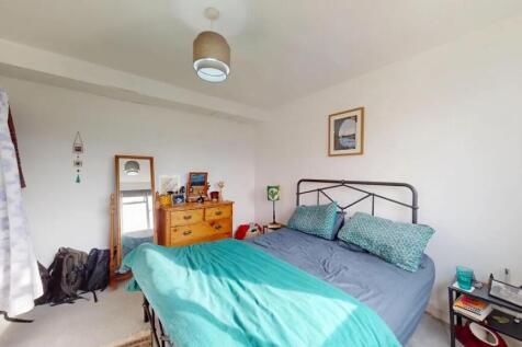 Bright double bedroom featuring a cozy metal be...