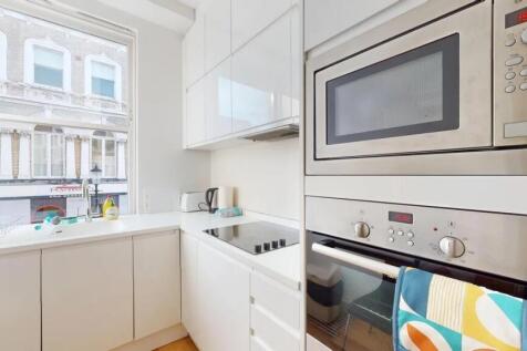 Bright and modern kitchen featuring sleek white...
