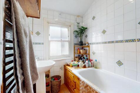 Bright and clean bathroom suite featuring a lar...
