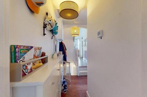 A bright and tidy hallway with white walls and ...