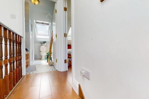 Bright and clean hallway featuring wooden floor...