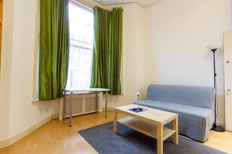 A bright and tidy living room featuring large w...