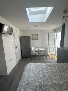 Bright and modern master bedroom featuring a la...