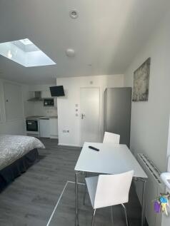 Bright and modern master bedroom featuring a co...