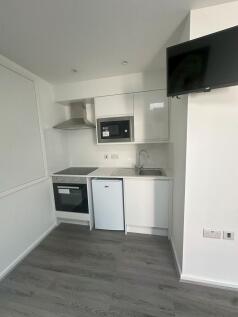 A modern and clean compact kitchen featuring wh...