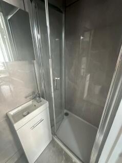 Modern bathroom with sleek grey tiles and a com...