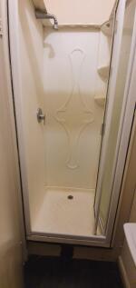 A compact shower area with a clean, white enclo...