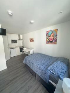 A well-maintained double bedroom with a neat be...