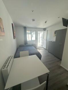 A bright and neat double bedroom featuring mode...