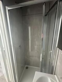 A modern bathroom featuring a clean, enclosed g...