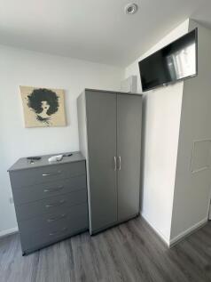 A tidy corner featuring a sleek grey chest of d...