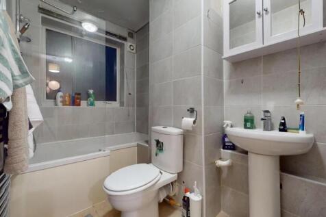A modern bathroom suite featuring a bath with s...