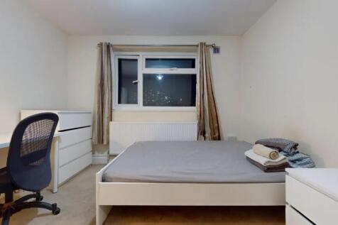 A neat and minimally furnished double bedroom w...