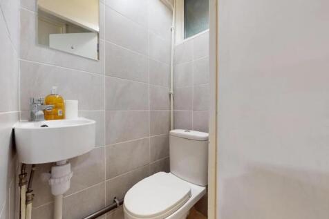 A compact, well-maintained single toilet featur...