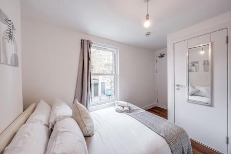 This inviting double bedroom features a cozy at...