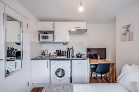 This modern kitchen area features sleek cabinet...