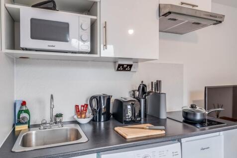 Modern kitchen featuring sleek cabinetry and es...