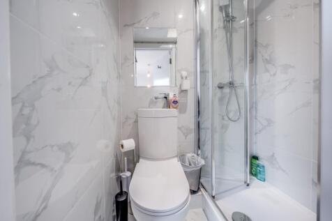 A modern bathroom featuring sleek marble tiles,...