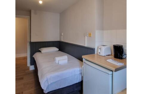 A tidy and inviting single bedroom with essenti...