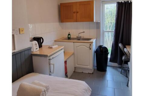 A tidy kitchenette with essential appliances an...