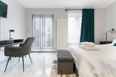 Bright and modern master bedroom featuring a co...