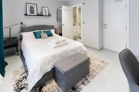 A stylish master bedroom featuring a comfortabl...