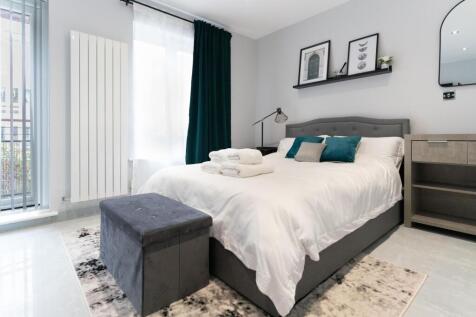 A stylish and well-lit double bedroom featuring...