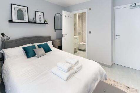 A neat and modern double bedroom featuring a co...
