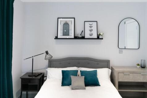 A modern and neatly arranged double bedroom fea...