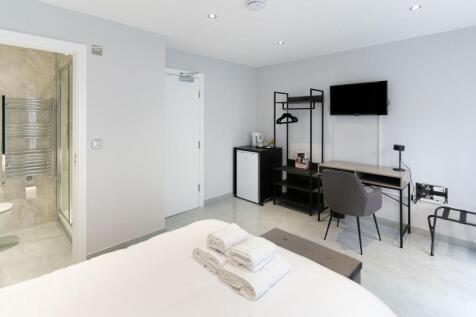 A modern double bedroom featuring a neatly made...